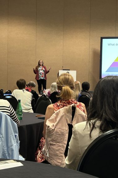 Cassie Christopher presents a wellness workshop to a large group of women